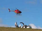 A helicopter spreading Optimise fertiliser.