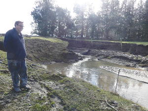 Chris Allen at a washout where a culvert burst in his Ashburton Forks farm during the big rain event at the end of May. Photo Credit: Nigel Malthus.