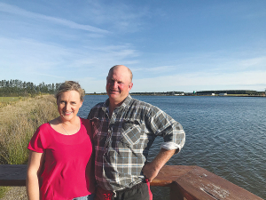 Geoff and Rochelle Spark with irrigation lake in background.