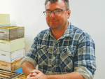 Waiau Apiaries’ Nick Belton with honey frames being held in a warming room before going to the centrifugal extractors.