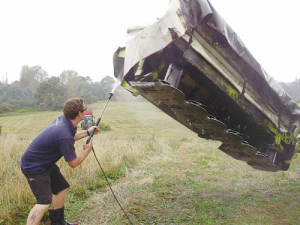 Waikato Regional Council biosecurity pest plants officer Ben Elliot cleans a machine after harvesting.