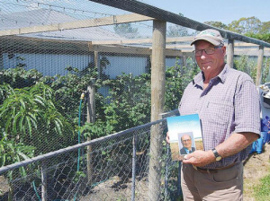 Allan Andrews with his autobiography ‘70 Years On’, beside the fruit cage on his retirement farmlet at Ashburton.