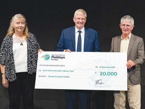 Rural Youth and Adult Literacy Trust trustees Jo Poland and Barry O’Donnell receiving the donation from Fieldays chief executive Peter Nation. 