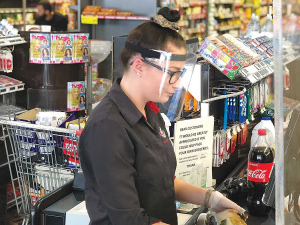 A supermarket worker wearing a face shield by Metalform.