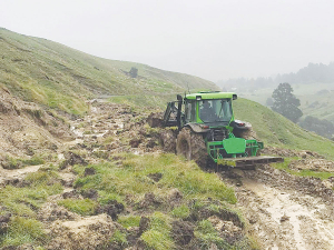 Bart Hadfield clearing a slip on the road to Mangaroa Station, about 60km northwest of Wairoa, following last month&#039;s flooding. Photo: Supplied.