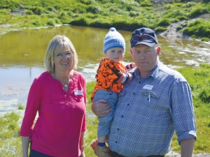 Marilyn and Gray Baldwin with grandson Peyton Baldwin with wetlands in the background.