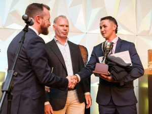 Reuben Alabaster, 2023 Youth Award Winner, receiving a handshake from Kieran McAnulty with Fonterra representative Luke McKee in the background.