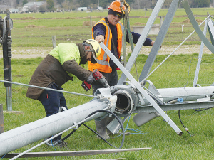 A Rainer Irrigation crew led by foreman Wame Ramalasou, left, works on an upturned pivot near Staveley in Mid-Canterbury. Their first task was to lift a section off a track to give the farmer full use of the farm again, before lifting it all back onto its wheels and assessing the full extent of the damage. Photo Credit: Nigel Malthus.