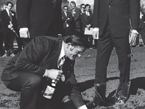 Frank Yukich placing a silver coin in the hole as the traditional token of good fortune for the new vine. Photo Credit: Marlborough Heritage Trust - Marlborough Archives.