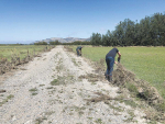 Farmy Army members fixing fencing on a flood-ravaged farm.