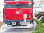 Lely Exos feeds fresh grass to cows in a barn.