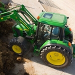 Dairy woman in driver’s seat with tractor workshop