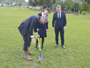 National’s primary industries spokesman Nathan Guy turns the first soil at Mt Albert Grammar School, watched by agribusiness student Fatima Imraan (17) and principal Patrick Drumm.