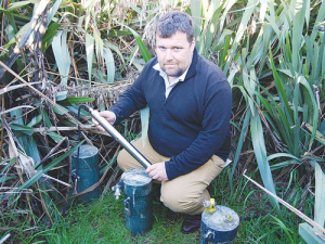 Lincoln Agritech’s Brian Miller with a prototype of the nitrate sensor beside sampling bores.