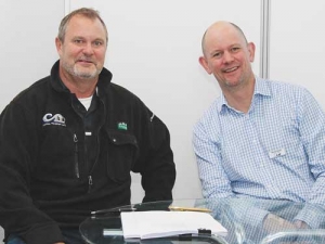 Brendon Cane (Precision Farming), left, and Wayne McNee (LIC) signing the agreement at National Fieldays.